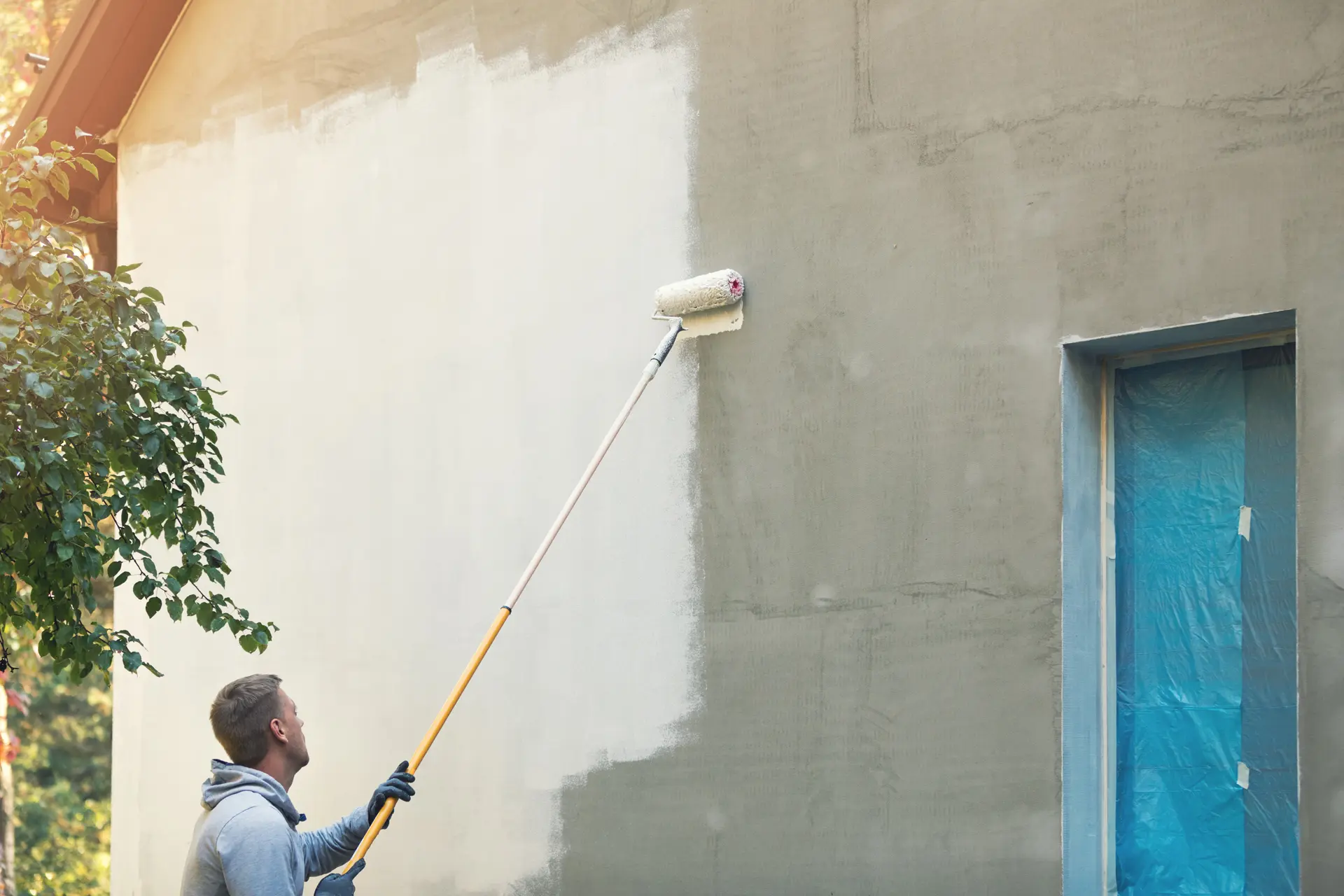 Pintor trabajando en una fachada en Gijón